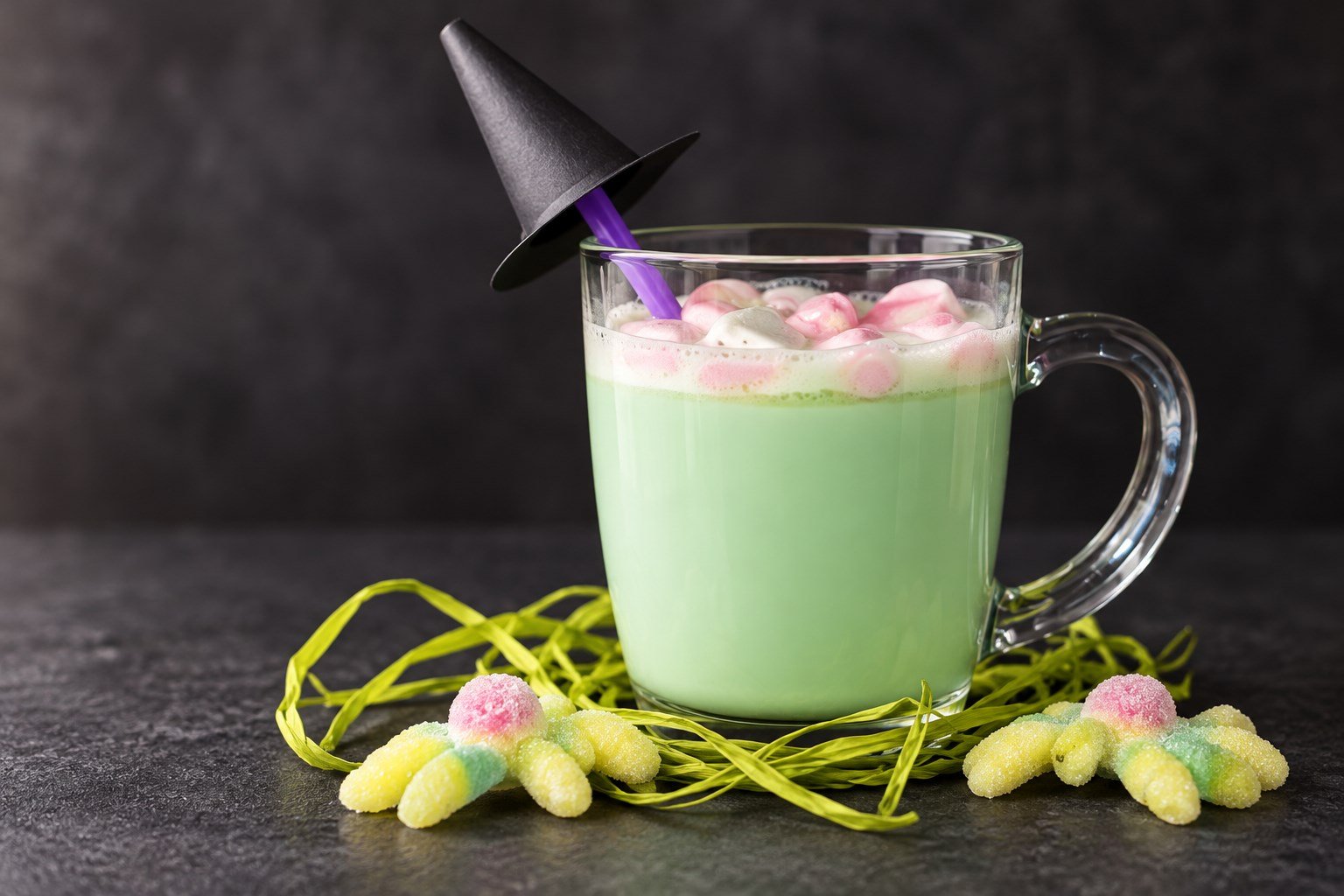 Brebaje de la bruja de chocolate blanco caliente con nubes rosas en una taza de cristal