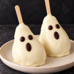 Dos peras fantasmas para Halloween cubiertas de chocolate blanco y decoradas con caras de chocolate negro