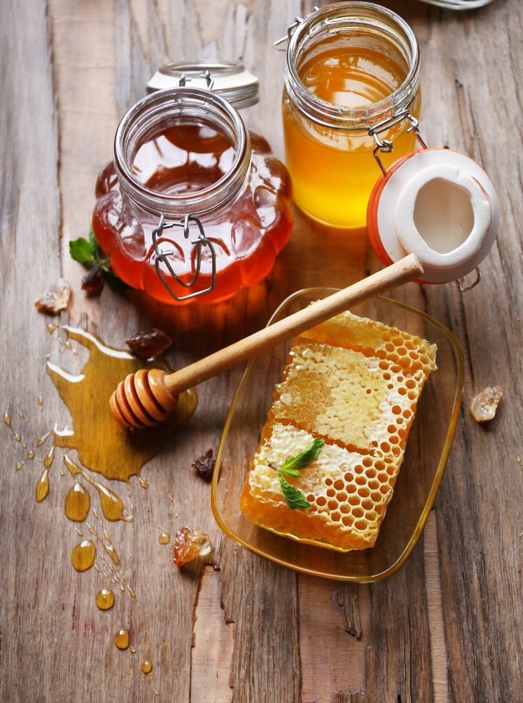 miel fresca en panal y tarro sobre mesa de madera